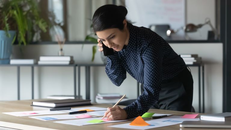 Woman writing post-it notes | Project management vs product management