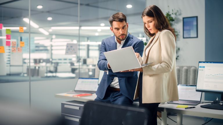 Employee working on task list on laptop | Project management vs. task management