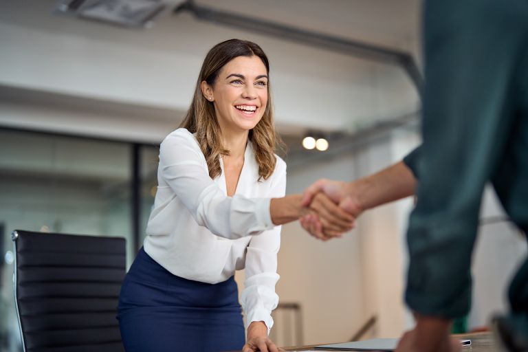 Woman shaking hands with agent | CRM for insurance agents